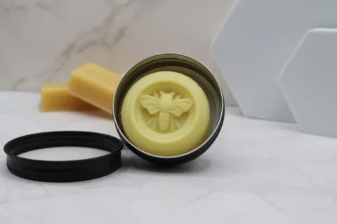 beeswax lotion bar in black tin