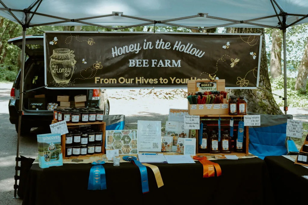 Farmer's Market at Tractor Supply 41 honey in the hollow event booth with honey and fair ribbons, recipe cards and pamphlets